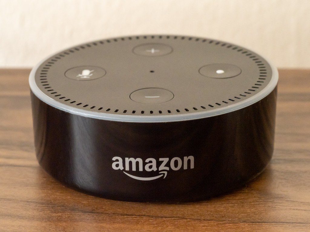 Amazon Echo Dot smart speaker on a wooden table, the kind of Alexa device that works well for seniors